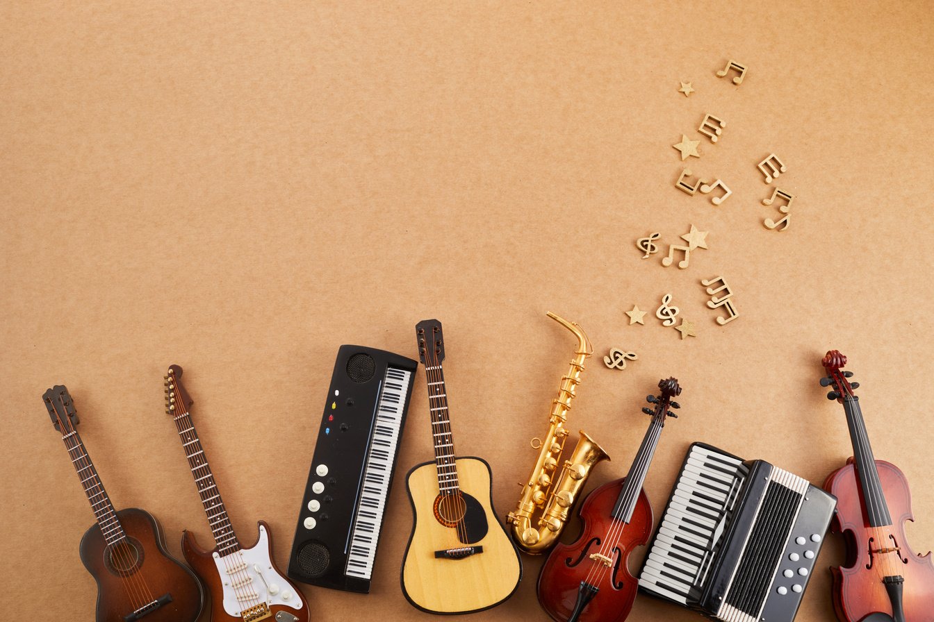 Happy world music day. Musical instruments on brown background.